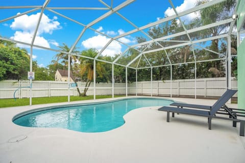 Private screened pool area with lounge chairs and garden views.