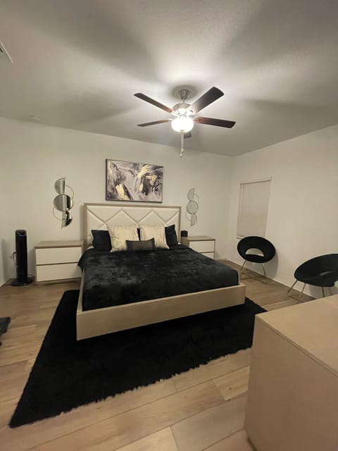 Primary bedroom on first floor with king bed, ceiling fan, 2 nightstands