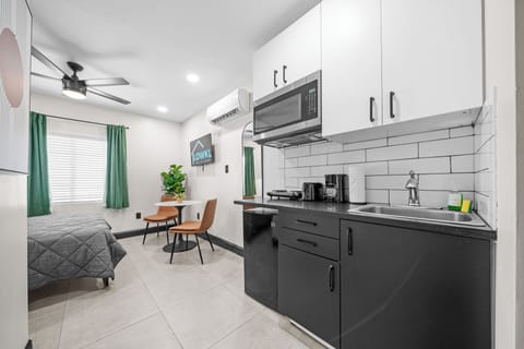 The kitchenette has all you need for a simple meal, including a microwave, mini-fridge, and essential appliances. A cozy dining area with a small table and two chairs provides a comfortable spot to enjoy your meals or work during your stay.
