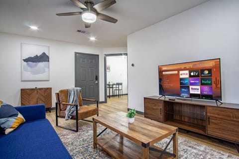 Bright and airy living room with plush seating, a large TV, and tasteful decor, creating the perfect space for relaxation and entertainment.