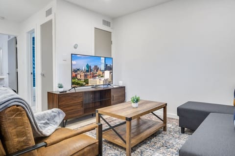 Bright and airy living room with plush seating, a large TV, and tasteful decor, creating the perfect space for relaxation and entertainment.