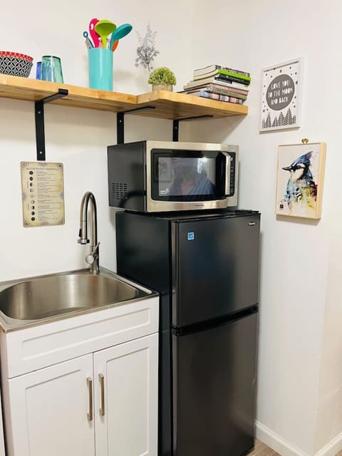 The equipment in the kitchenette incorporates a microwave, coffee machine, hotel style refrigerator/freezer, tea kettle, induction flat top, and toaster