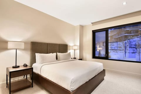 Bright bedroom with a king bed and large windows.