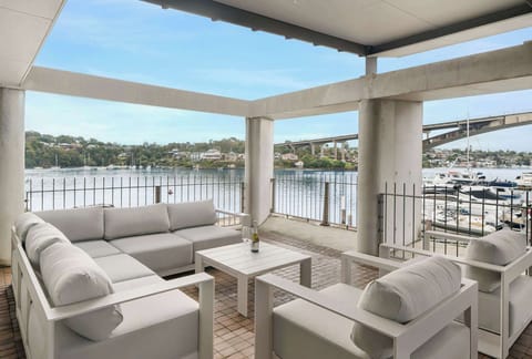 Enjoy the expansive 180-degree views from the balcony on a comfortable sofa paired with a charming small table