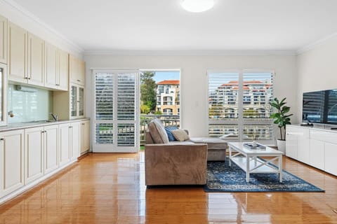 Imagine mornings with sunshine filtering through plantation shutters. This space offers a comfortable sofa for unwinding and a practical kitchenette.
