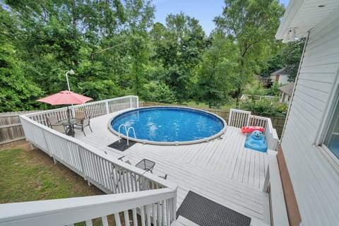 Elevated view of the private round pool with lounge chairs, umbrellas, and a spacious sun deck.