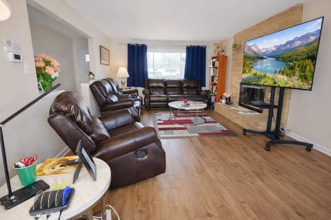 Living room with leather sofa, loveseat, recliner, 65" Roku TV w/spectrum.