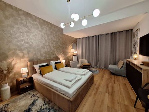 A comfortable studio featuring a double bed, soft lighting, and elegant wallpaper.
