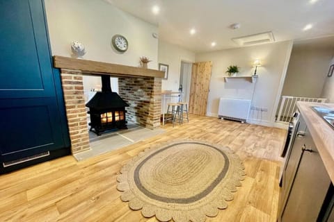 Cook in the modern kitchen at Moat Cottage, featuring a two-way log burner that warms both the kitchen and the cosy lounge, perfect for a relaxed stay.