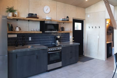 Kitchen includes electric range, microwave, fridge, coffee pot, s+p, olive oil, coffee, and more