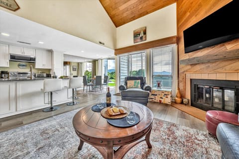 The living room`s large windows let in natural light, creating a warm and inviting space.