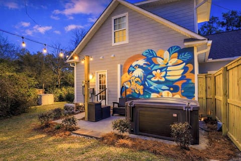Relax under the glow of string lights in the private hot tub courtyard at The Montague on Magnolia. Enjoy the colorful coastal mural, cozy seating, and a peaceful fenced backyard just steps from downtown Ocean Springs.