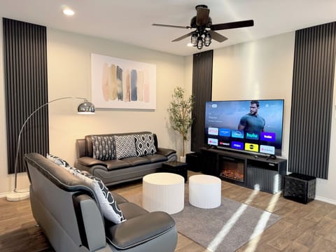 Stylish living area has a 75" 4K Smart TV and an electric fireplace