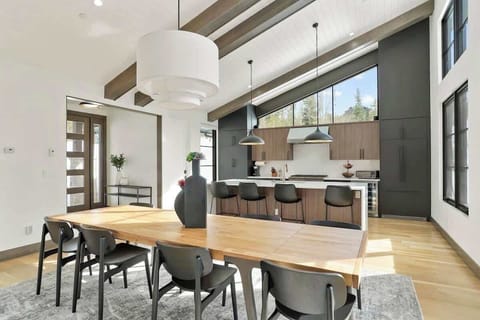 - Entertain with ease in our open-concept dining area and kitchen, featuring a spacious table for group gatherings. The modern design and high ceilings create an airy and sophisticated atmosphere.