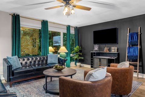 The living room has a bar equipped with bourbon glasses and wine glasses along with a cocktail book