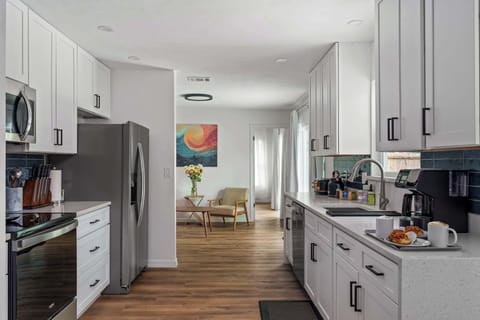 Enjoy the open and airy layout that connects the modern kitchen to our cozy living areas. This view showcases the home’s beautiful wood flooring and the effortless transition from meal prep to relaxation.
