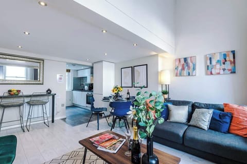 The open-plan living room and dining area benefit from a 50-inch Smart TV, a 4-seater dining table,  a 3-seater breakfast bar, plenty of space to sit down in the evenings and a double sofa bed.