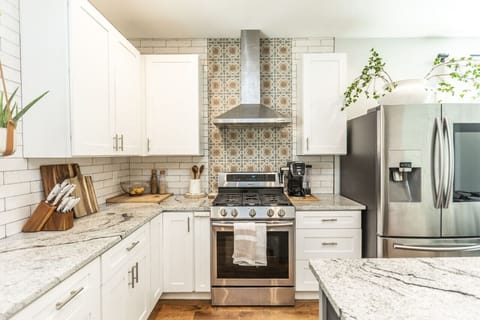 A spacious kitchen equipped with everything you need to cook: utensils, pots, pans, baking tools, bowls, spices, oil, tea, coffee, sugar, and all the basic kitchen supplies!