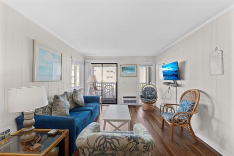 Living Room - Living area with seating, TV, and sliding doors that lead directly to the balcony.
