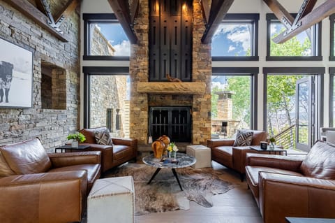 Living area with plush sofa, smart TV, gas fireplace, and main level deck access
