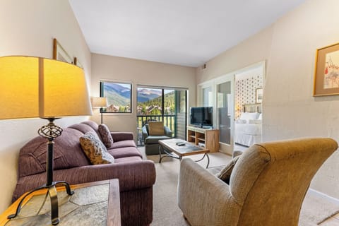 Settle into your cozy living room where mountain views frame every moment of relaxation through panoramic windows.