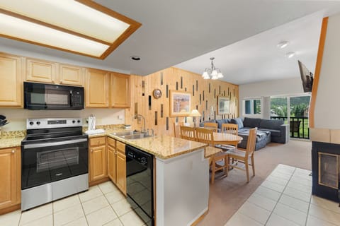 Your mountain retreat features an open-concept kitchen and living space with granite counters, modern appliances, and cozy fireplace for memorable evenings together.
