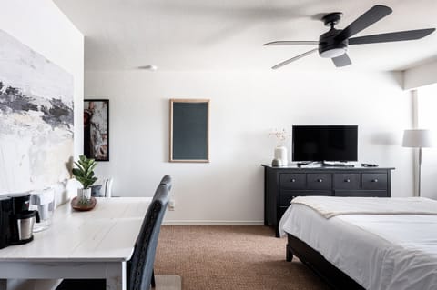 Queen Studio Unit, with workspace and basic kitchenette area, open and bright.