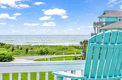 Beachfront balcony with turquoise Adirondack chairs and direct ocean views