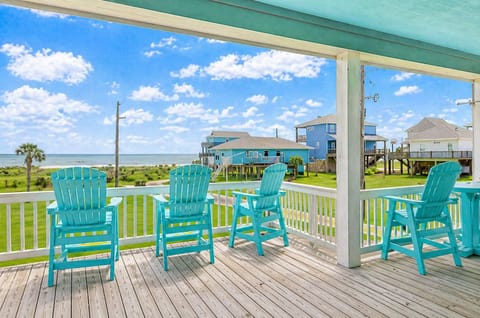 Covered deck with bright Adirondack chairs overlooking coastal neighborhood