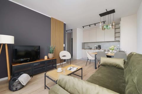 Bright and elegant living area with modern furniture, green tones, and wood accents creating a relaxing atmosphere.