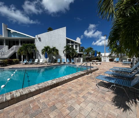 Main pool at Madeira Beach Yacht Club. It is a large heated and - Main pool at Madeira Beach Yacht Club. It is a large heated and saltwater pool. Plus pool bathrooms to the left, and numerous lounge chairs and tables!