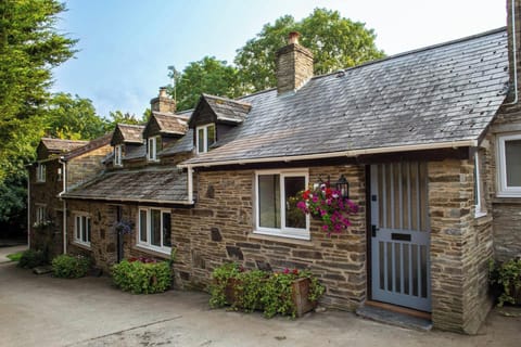 Freesia Cottage with hanging basket and potted plants outside