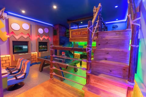 Discover a vibrant play space with colorful lighting and playful decor that invites fun and adventure. A unique wooden staircase leads to an imaginative loft, while cozy seating offers the perfect spot for relaxation and games.