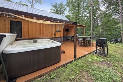 Spacious outdoor relaxation - covered patio with TV, dining space, grill, hot tub and steps away from firepit area