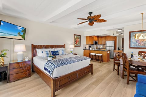 Unwind in your tropical haven with a king bed, full kitchen, and island-inspired decor beneath exposed beams and a palm leaf ceiling fan.