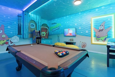 Discover a lively game room adorned with vibrant murals of beloved characters. Challenge friends to a game at the sleek pool table, all while the soft lighting creates an inviting atmosphere for a delightful evening.