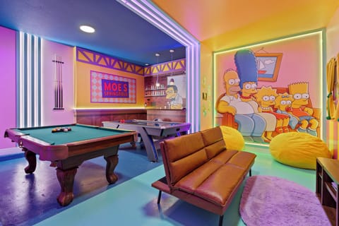 Welcome to the vibrant game room, where colorful walls and playful decor set a fun and relaxing atmosphere. Unwind on the sleek brown sofa or enjoy hours of entertainment at the pool table, creating memorable moments with friends.