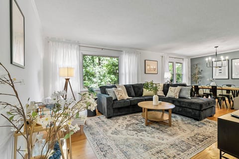 Large living room with cozy lounges and a view of the dining area at the far end
