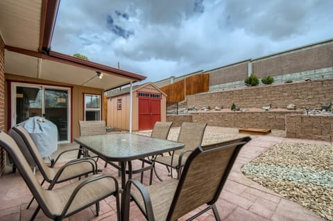 Private backyard with dining furniture and charcoal grill.
