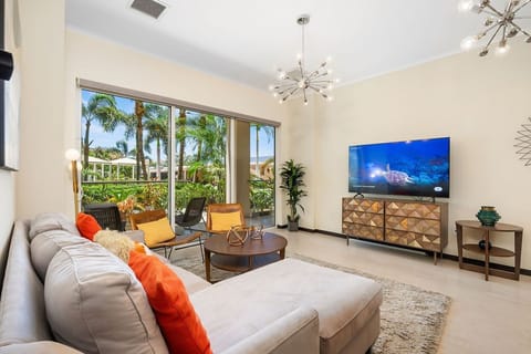 The glass doors flood the room with natural light, complementing the cozy interior design. A wall-mounted TV adds entertainment for a perfect space to enjoy during your stay.