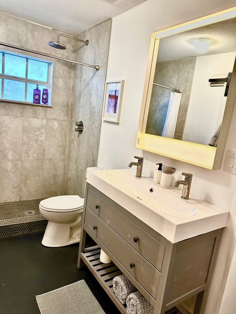 Private bath with rain shower, double sink, and all essentials stocked. 