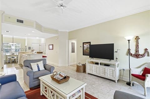 The spacious living room features lots of seating and a 65" Smart Samsung TV.