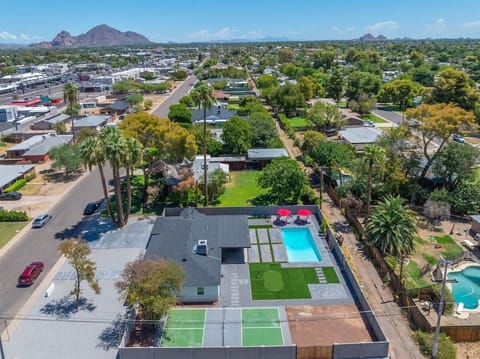 Bird’s-eye look at the home and backyard pool, framed by tree-lined streets and a mountain backdrop—get a feel for the layout before you arrive.