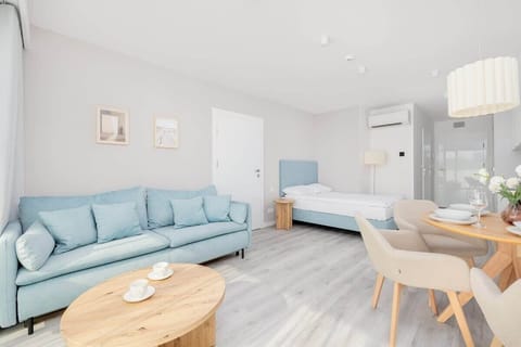 A cozy living room with a comfortable sofa bed and a dining area for shared meals. Bright, modern interior with elegant decor.