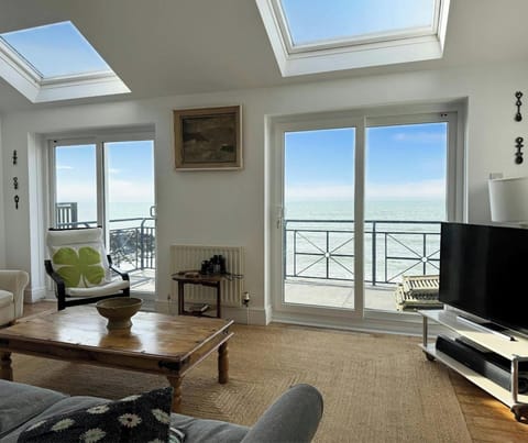 Sitting room with sofa, coffee table, tv, doors to terrace and sea view