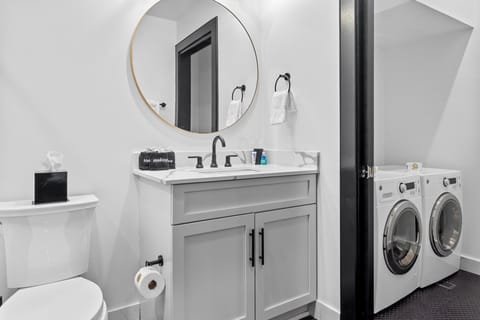 The primary bathroom offers sleek finishes, a soaking tub with Smart TV, walk-in shower, and plush towels. Spacious and private, it adds a luxurious touch to your suite—perfect for unwinding after a day in Downtown New Orleans.