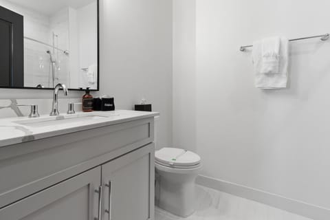 The guest bathroom includes fresh towels, a hairdryer, and complimentary toiletries. Conveniently located near the living area, it's stylish and practical—perfect for guests, families, or sharing during group stays at 888 Baronne.