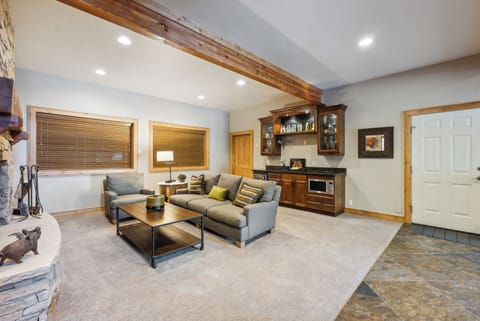 - Downstairs living room with fireplace and comfy sofa  
- Built-in wet bar with glass cabinets and sink area  
- Perfect space for entertaining or relaxing indoors