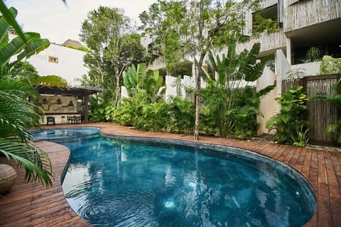 Community pool and terrace surrounded by lush jungle