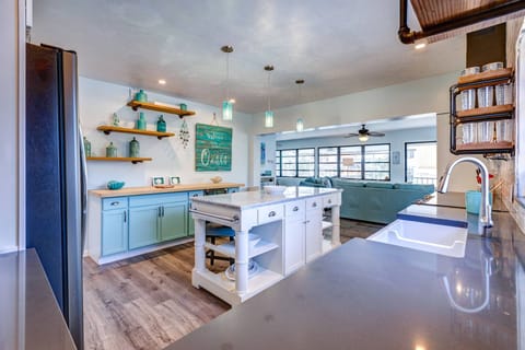 This kitchen boasts a stylish island and ample countertops, offering plenty of space for meal prep, cooking, and entertaining.